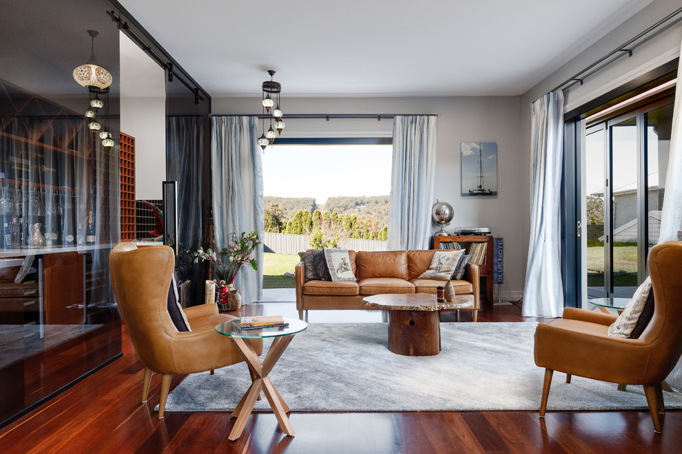 Стильный дизайн: гостиная комната в современном стиле с серыми стенами, паркетным полом среднего тона и коричневым полом - последний тренд