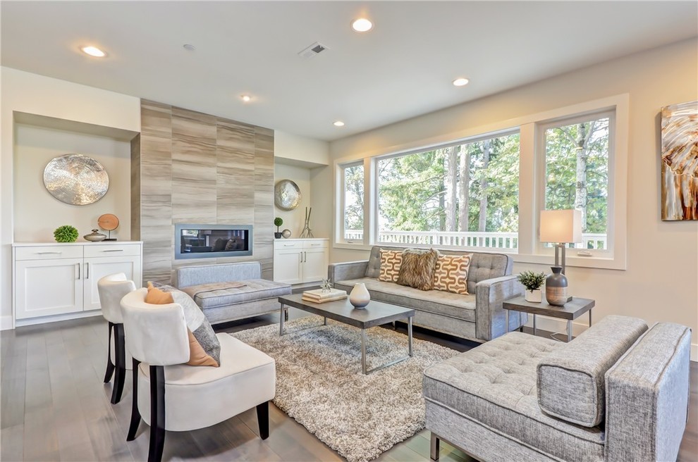 Large contemporary formal open plan living room in Seattle with white walls, medium hardwood flooring, a ribbon fireplace, a tiled fireplace surround, no tv and brown floors.