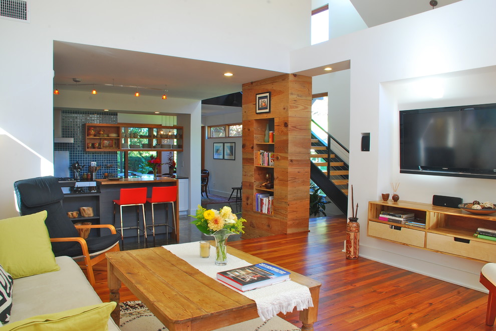 Aménagement d'un petit salon moderne ouvert avec un mur blanc, un sol en bois brun et un téléviseur fixé au mur.