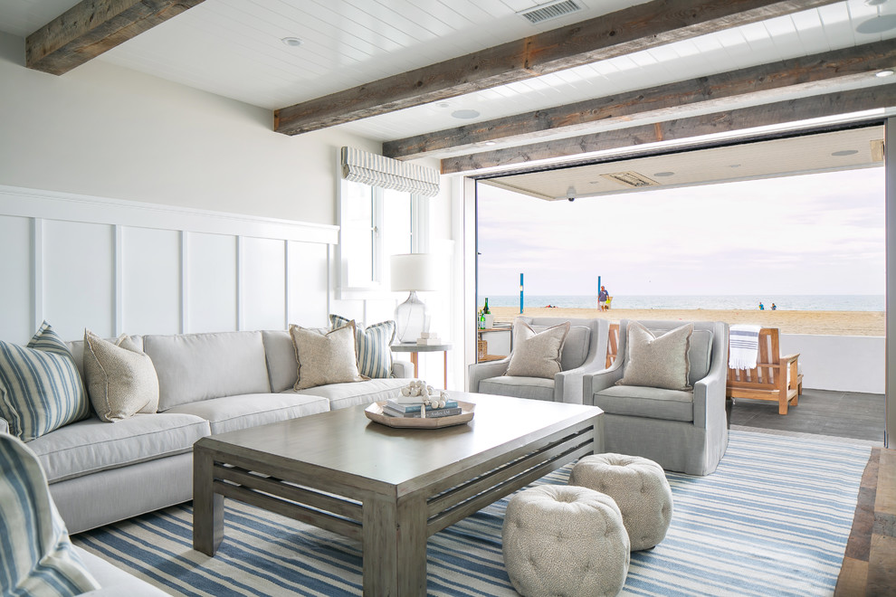Inspiration for a medium sized coastal formal open plan living room in Orange County with beige walls, medium hardwood flooring, a standard fireplace, a tiled fireplace surround, a wall mounted tv and brown floors.