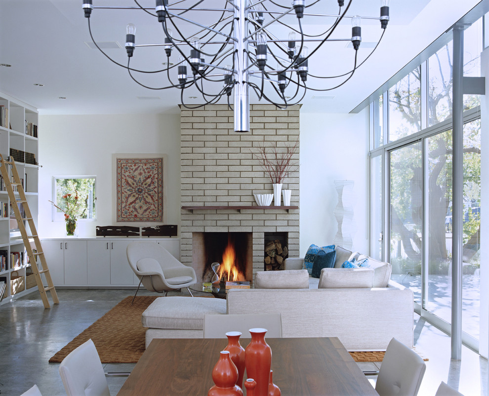 Living room library - mid-sized modern open concept concrete floor and gray floor living room library idea in Los Angeles with white walls, a standard fireplace, a tile fireplace and no tv