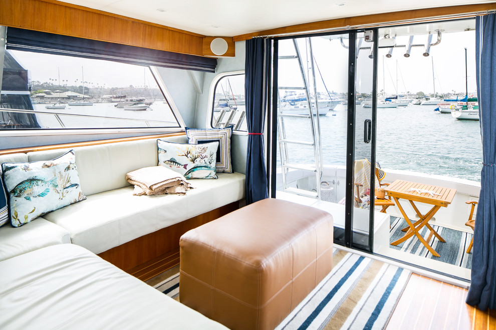 Foto di un piccolo soggiorno stile marino aperto con pareti blu, pavimento in legno massello medio, parete attrezzata e pavimento marrone