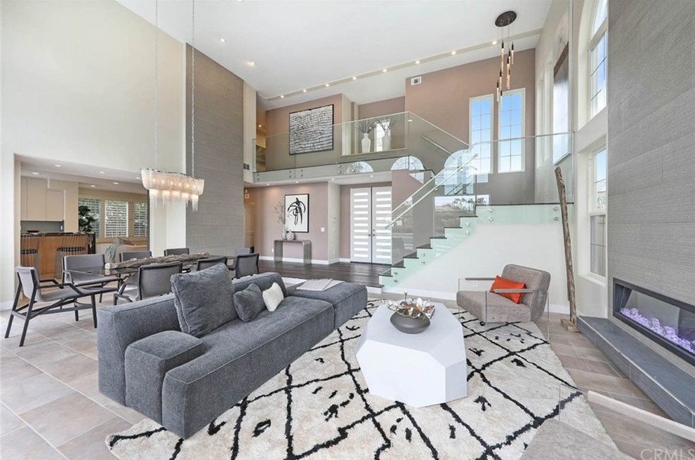 Großes, Offenes Modernes Wohnzimmer mit Porzellan-Bodenfliesen, Kamin, gefliester Kaminumrandung und grauem Boden in Orange County