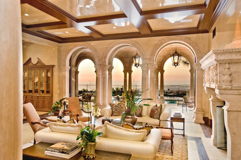 This is an example of a large mediterranean formal open plan living room in Orange County with beige walls, limestone flooring, a standard fireplace, a stone fireplace surround, no tv and beige floors.