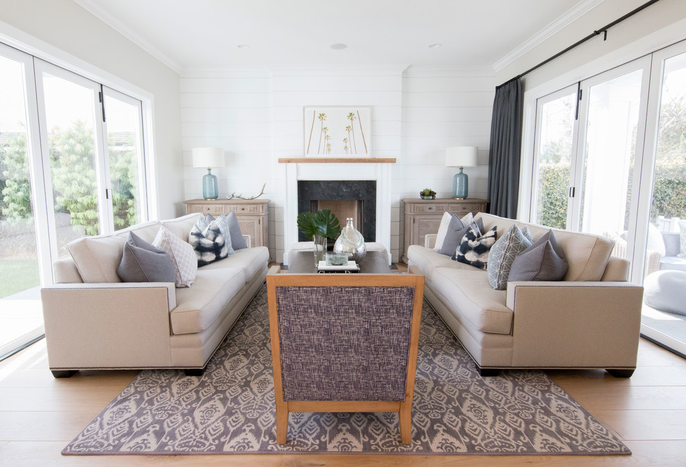 Example of a large farmhouse formal and open concept light wood floor living room design in Orange County with white walls, a standard fireplace, a stone fireplace and no tv