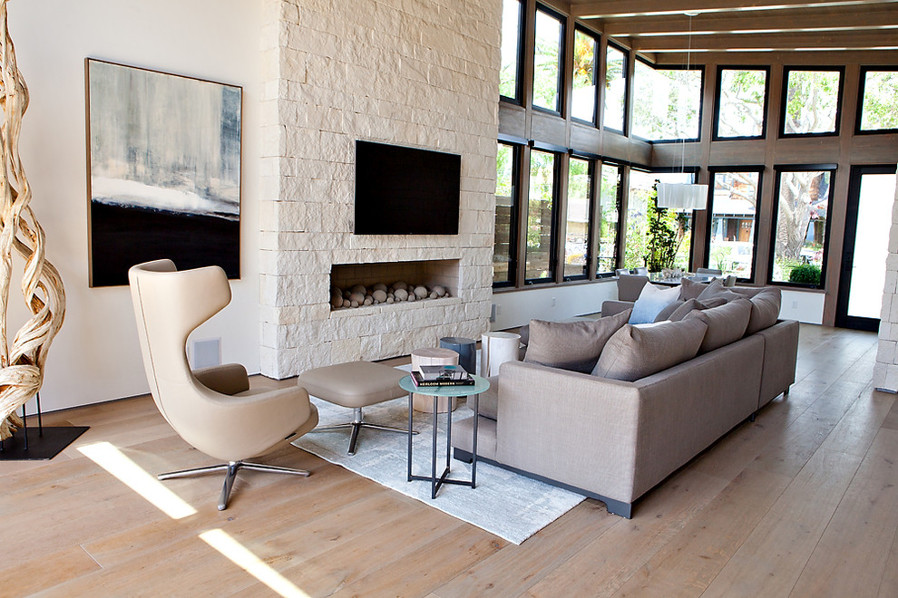 Example of a large trendy formal and enclosed light wood floor and beige floor living room design in Orange County with white walls, a ribbon fireplace, a stone fireplace and a media wall