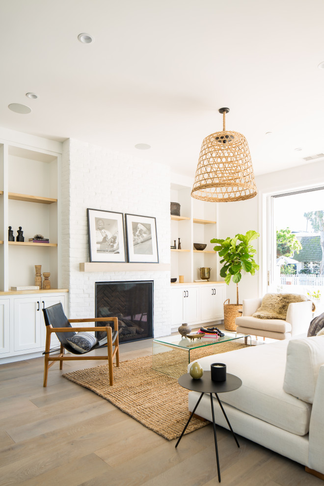 Medium sized rural open plan living room in Orange County with light hardwood flooring, a standard fireplace and a brick fireplace surround.