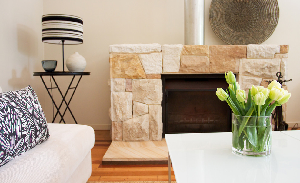 Mittelgroßes, Repräsentatives, Fernseherloses, Offenes Modernes Wohnzimmer mit beiger Wandfarbe, braunem Holzboden, Kamin und Kaminumrandung aus Stein in Sydney