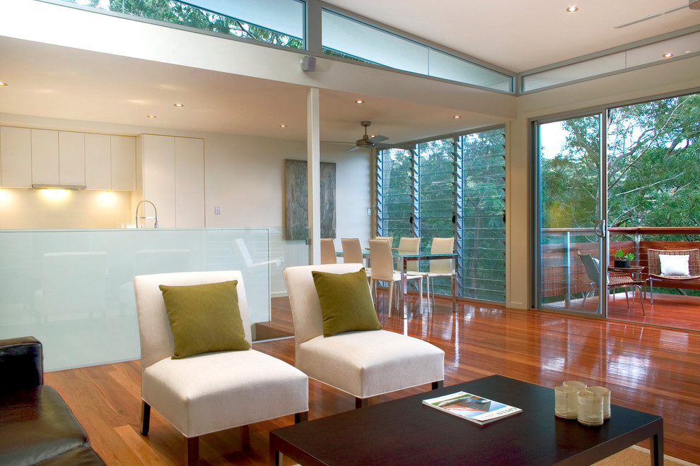 Contemporary open plan living room in Sydney with white walls and medium hardwood flooring.