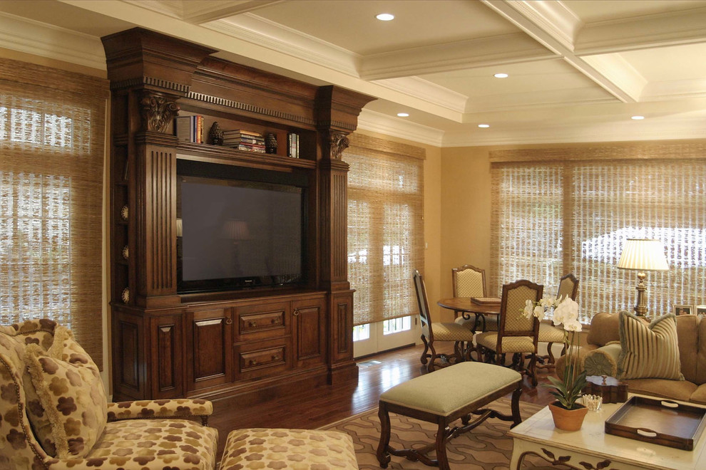Example of a large classic enclosed dark wood floor and brown floor living room design in Boston with beige walls and a media wall