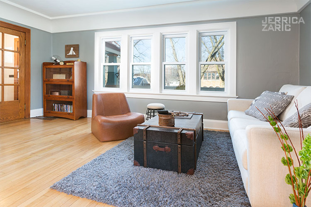 Kleines, Offenes Industrial Wohnzimmer mit grauer Wandfarbe, hellem Holzboden, freistehendem TV und braunem Boden