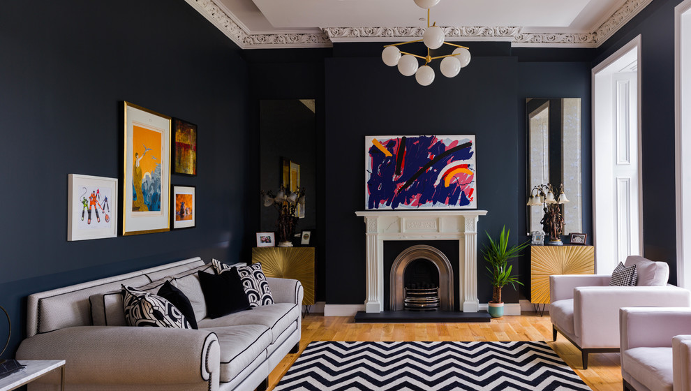 Bohemian enclosed living room in Glasgow with blue walls, medium hardwood flooring, a standard fireplace and brown floors.