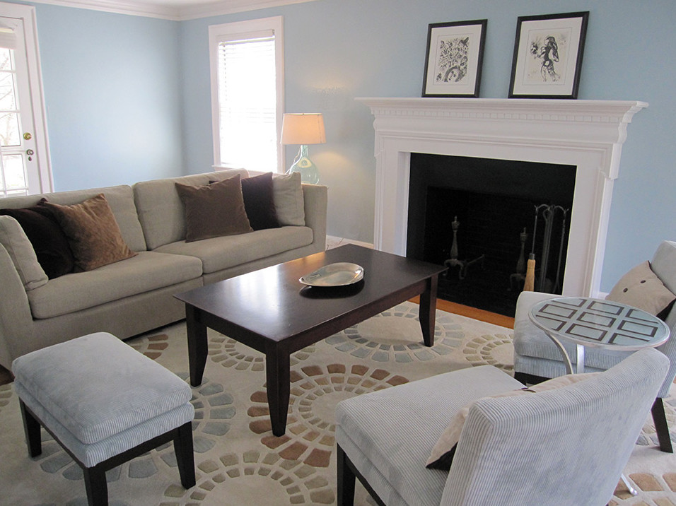 Small classic enclosed living room in Boston with blue walls, light hardwood flooring, a standard fireplace, a wooden fireplace surround and a freestanding tv.