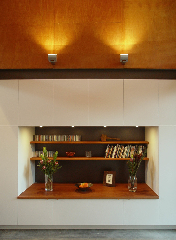 Aménagement d'un salon moderne de taille moyenne et ouvert avec un mur blanc, sol en béton ciré et un téléviseur dissimulé.