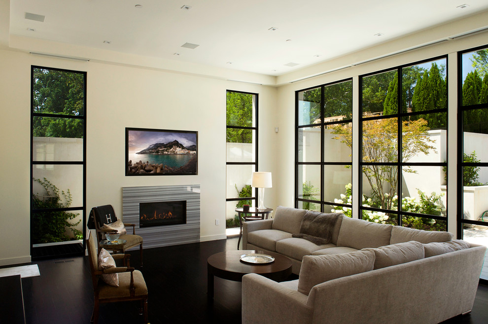 ワシントンD.C.にある高級な中くらいなコンテンポラリースタイルのおしゃれなLDK (濃色無垢フローリング、壁掛け型テレビ、横長型暖炉、金属の暖炉まわり、白い壁、黒い床) の写真