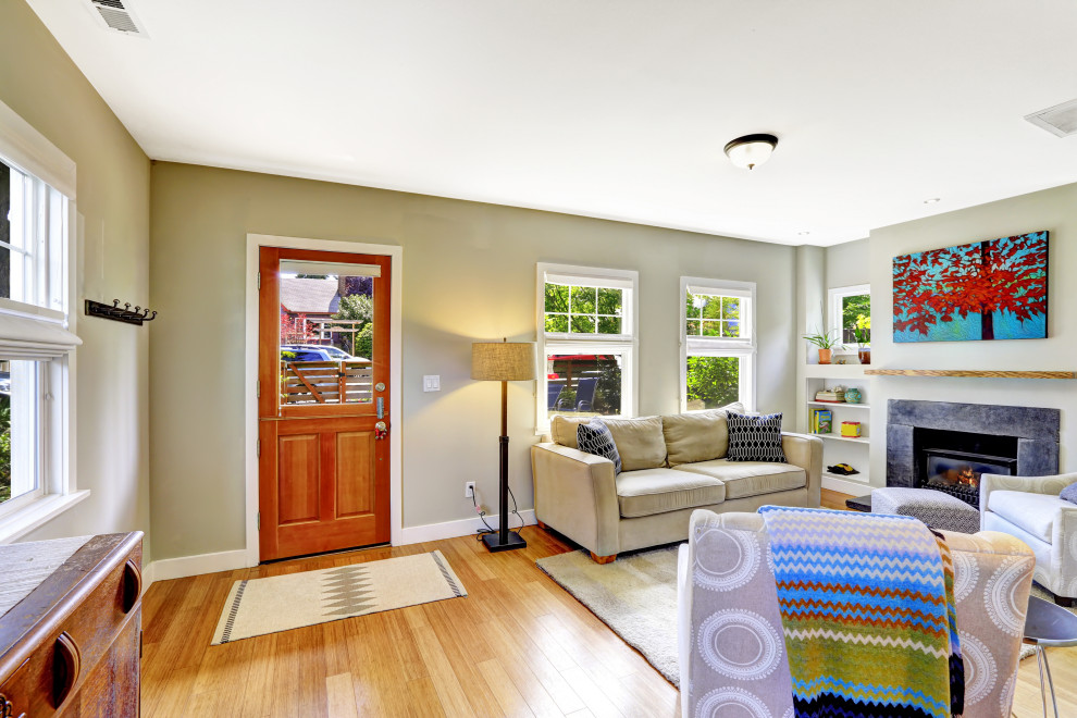 Стильный дизайн: маленькая открытая гостиная комната в стиле кантри с зелеными стенами, светлым паркетным полом, стандартным камином и фасадом камина из бетона без телевизора для на участке и в саду - последний тренд