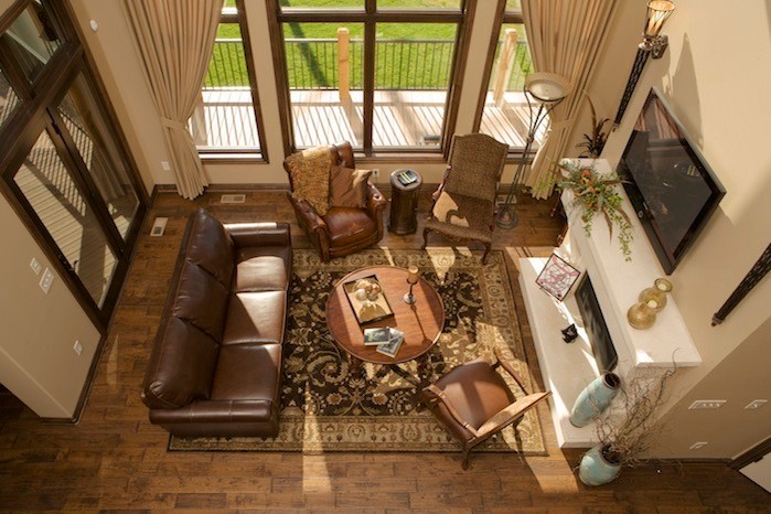Inspiration pour un salon traditionnel de taille moyenne et ouvert avec un mur beige, un sol en bois brun, une cheminée standard, un manteau de cheminée en béton et un téléviseur fixé au mur.