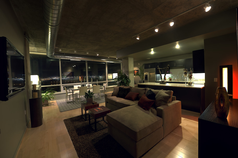 Ispirazione per un grande soggiorno contemporaneo stile loft con pareti beige, parquet chiaro, nessun camino, TV a parete e pavimento marrone