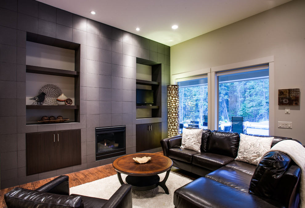 Aménagement d'un salon contemporain avec un mur gris, une cheminée standard et un téléviseur encastré.