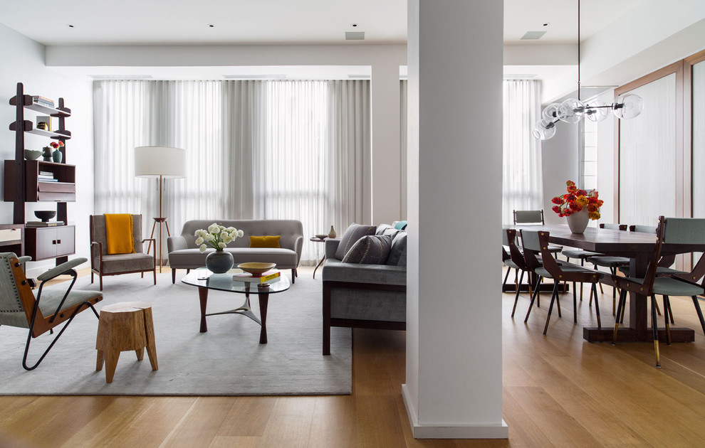 Стильный дизайн: гостиная комната в современном стиле с белыми стенами и паркетным полом среднего тона - последний тренд