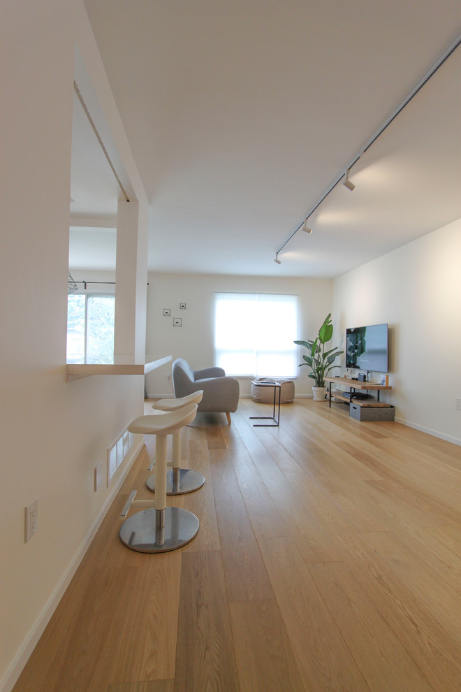 Small scandi formal open plan living room in Toronto with white walls, light hardwood flooring, no fireplace and a wall mounted tv.