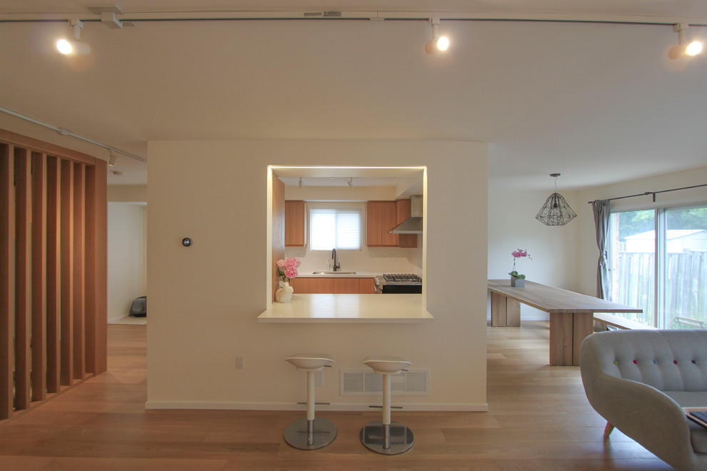 Idéer för små minimalistiska allrum med öppen planlösning, med ett finrum, vita väggar, ljust trägolv och en väggmonterad TV