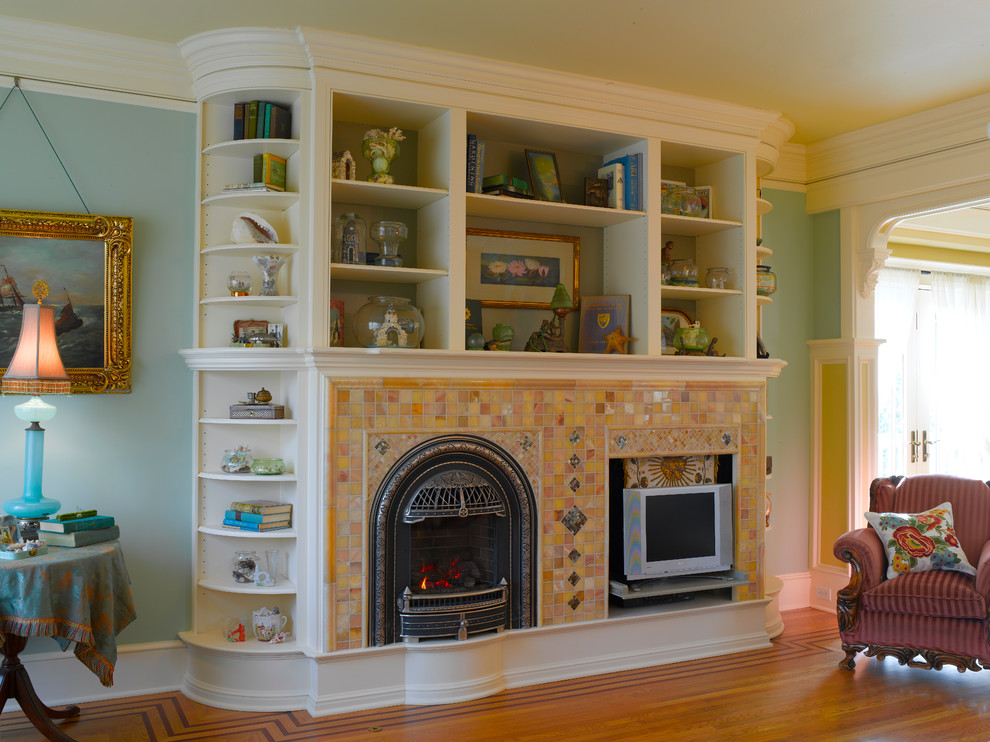 Exempel på ett stort klassiskt vardagsrum, med ljust trägolv, en standard öppen spis, en spiselkrans i trä och blå väggar