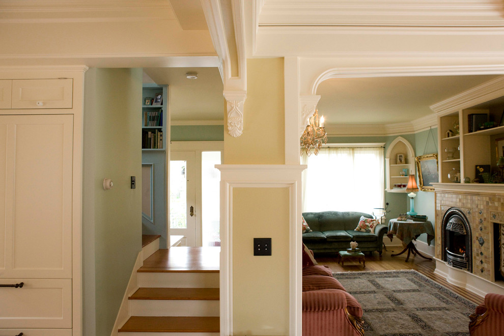 Источник вдохновения для домашнего уюта: большая гостиная комната в классическом стиле с желтыми стенами, светлым паркетным полом, стандартным камином и фасадом камина из плитки
