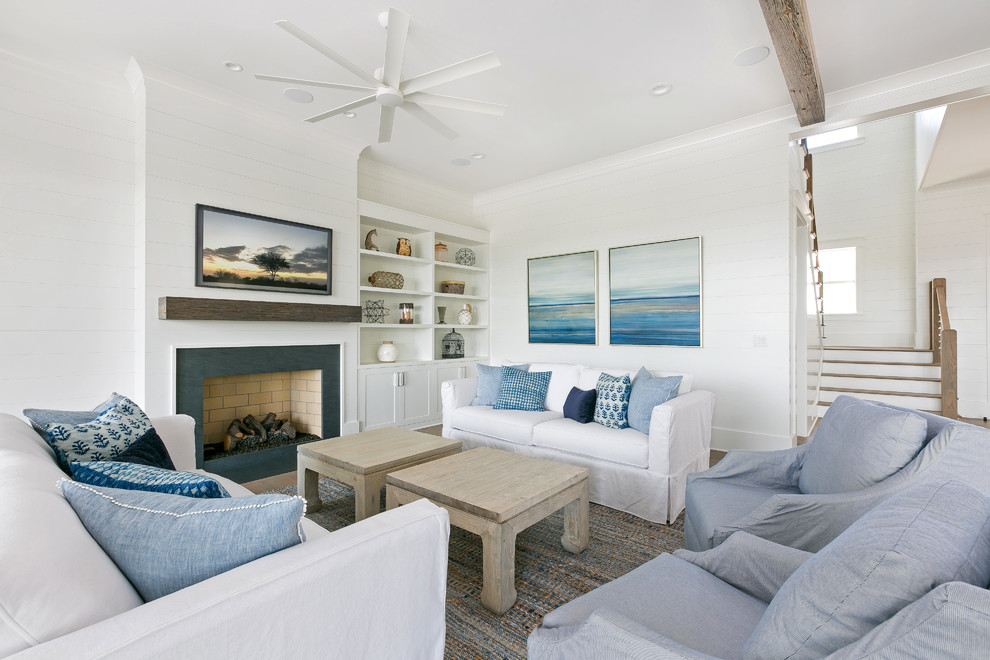 Inspiration for a mid-sized coastal open concept painted wood floor and brown floor living room remodel in Charleston with white walls, a standard fireplace, a stone fireplace and a wall-mounted tv