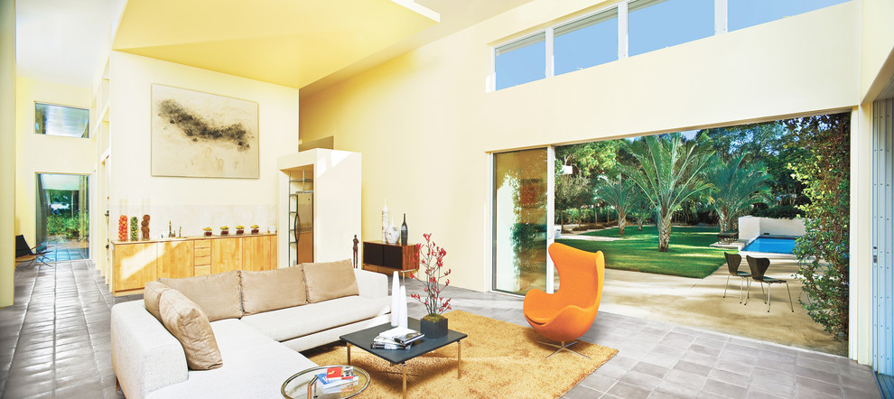 Idee per un grande soggiorno design aperto con pareti gialle e pavimento in terracotta