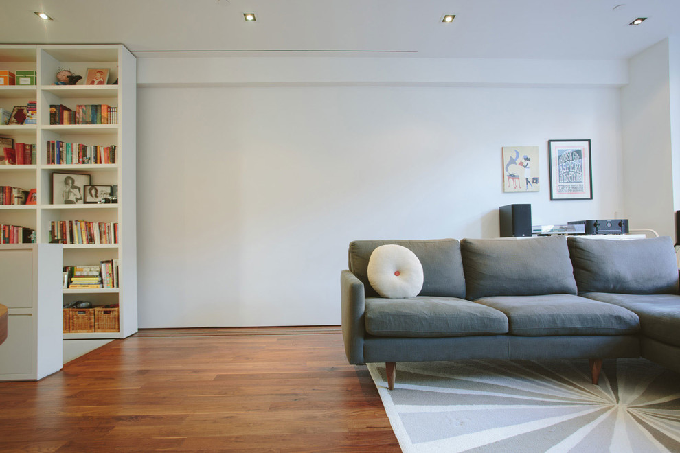 Modelo de salón abierto contemporáneo pequeño con paredes blancas y suelo de madera en tonos medios
