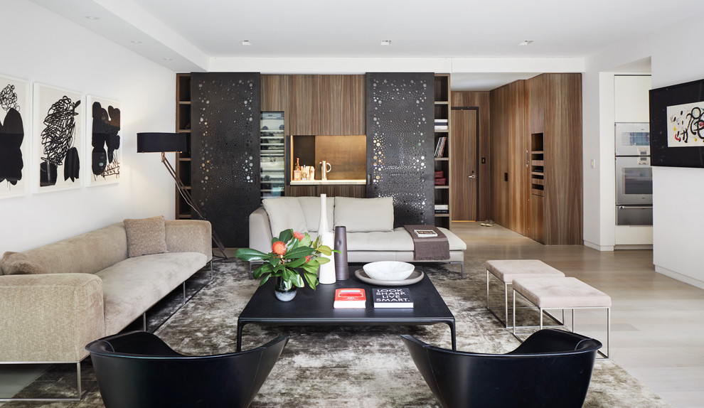 Offenes Modernes Wohnzimmer mit Hausbar, weißer Wandfarbe und hellem Holzboden in New York