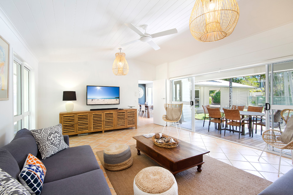 This is an example of a medium sized coastal living room in Sunshine Coast with beige walls and terracotta flooring.