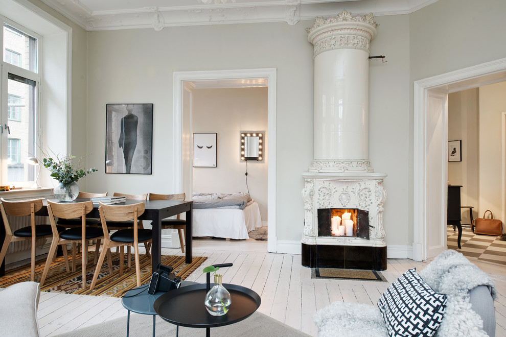 Large danish formal painted wood floor living room photo in Gothenburg with beige walls and a wood stove