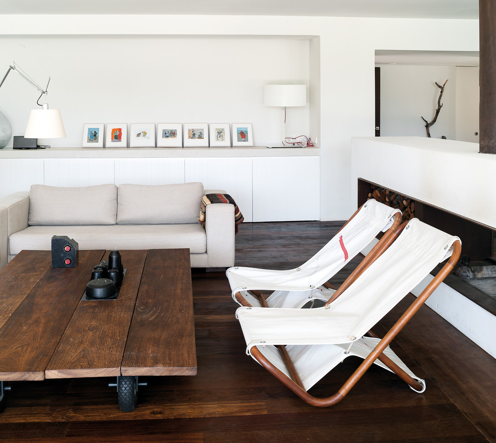 Cette image montre un salon nordique de taille moyenne avec un mur blanc, parquet foncé, une cheminée ribbon, une salle de réception et aucun téléviseur.