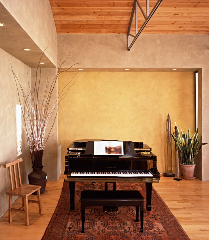 Example of a large minimalist open concept light wood floor and beige floor living room design in San Francisco with a music area, gray walls, a standard fireplace, a stone fireplace and no tv