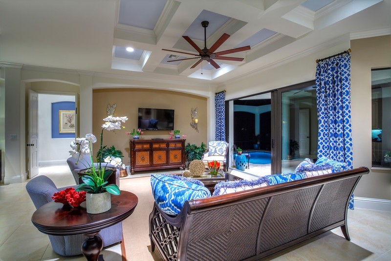 Foto di un soggiorno tropicale di medie dimensioni e aperto con pareti beige, TV a parete e pavimento bianco