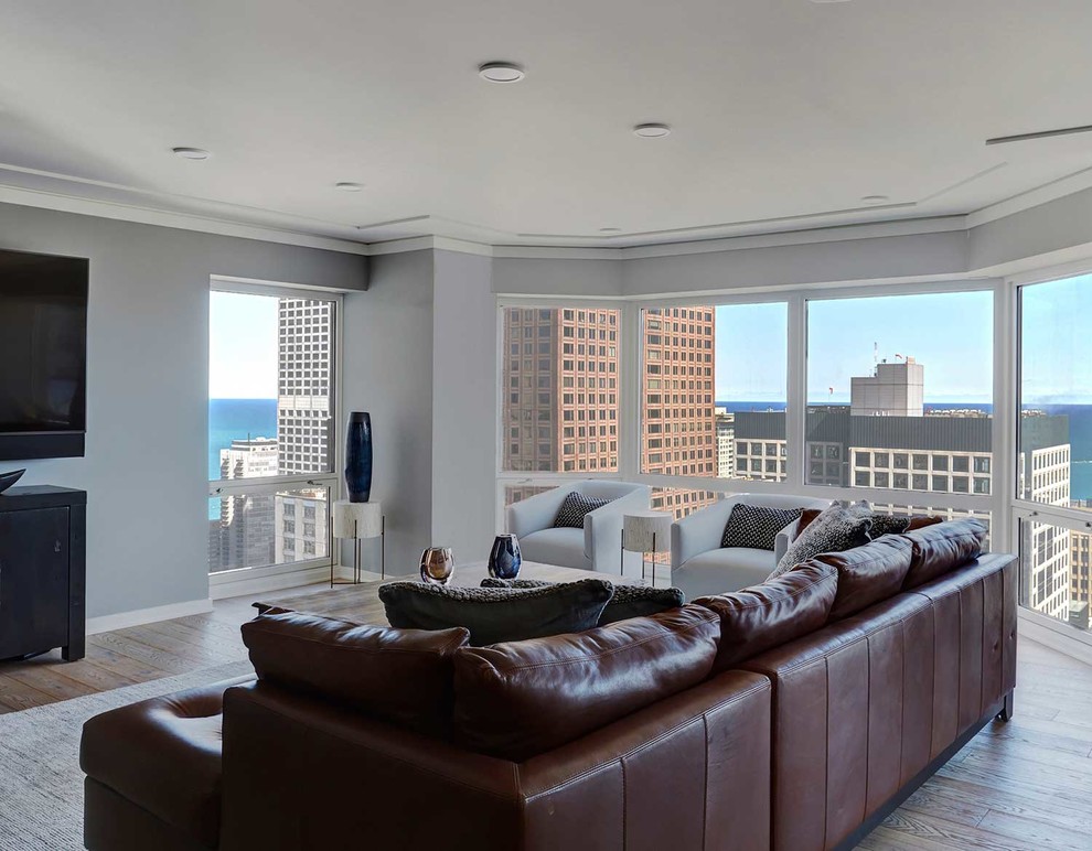 Großes Modernes Wohnzimmer ohne Kamin, im Loft-Stil mit grauer Wandfarbe, freistehendem TV, braunem Boden und hellem Holzboden