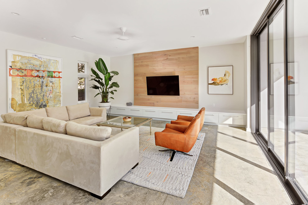 Example of a large minimalist enclosed gray floor and concrete floor living room design in Jacksonville with white walls, a wall-mounted tv and no fireplace