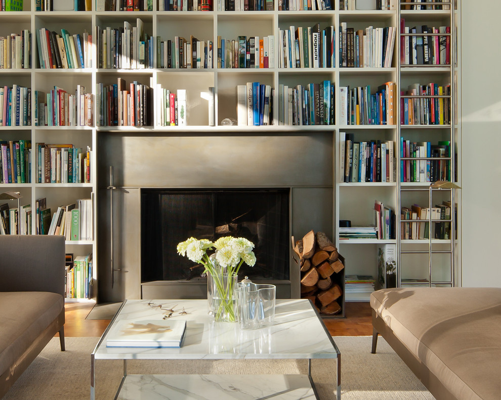 Diseño de biblioteca en casa abierta moderna de tamaño medio con paredes blancas, todas las chimeneas y marco de chimenea de hormigón