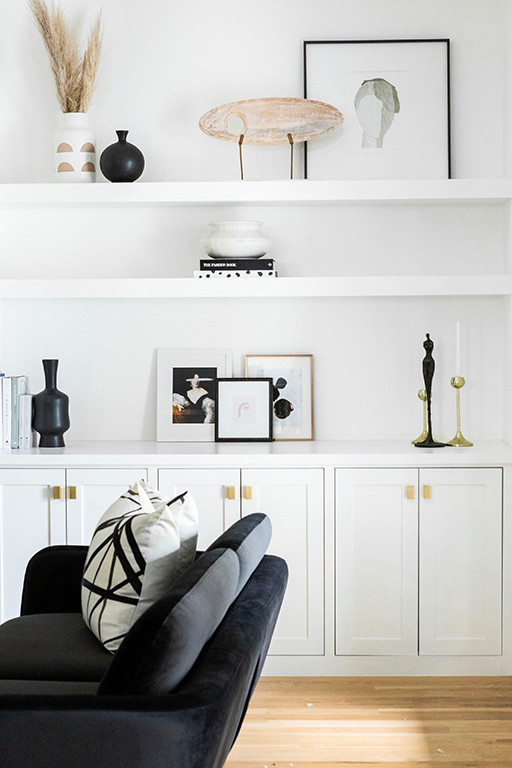 Idée de décoration pour un grand salon minimaliste ouvert avec un mur blanc, parquet clair, cheminée suspendue, un manteau de cheminée en plâtre, un téléviseur fixé au mur et un sol marron.