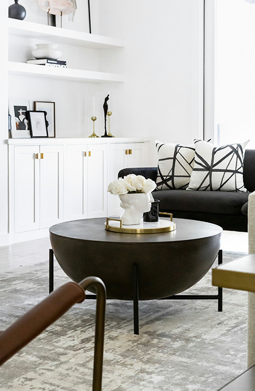 Cette image montre un grand salon minimaliste ouvert avec un mur blanc, parquet clair, cheminée suspendue, un manteau de cheminée en plâtre, un téléviseur fixé au mur et un sol marron.