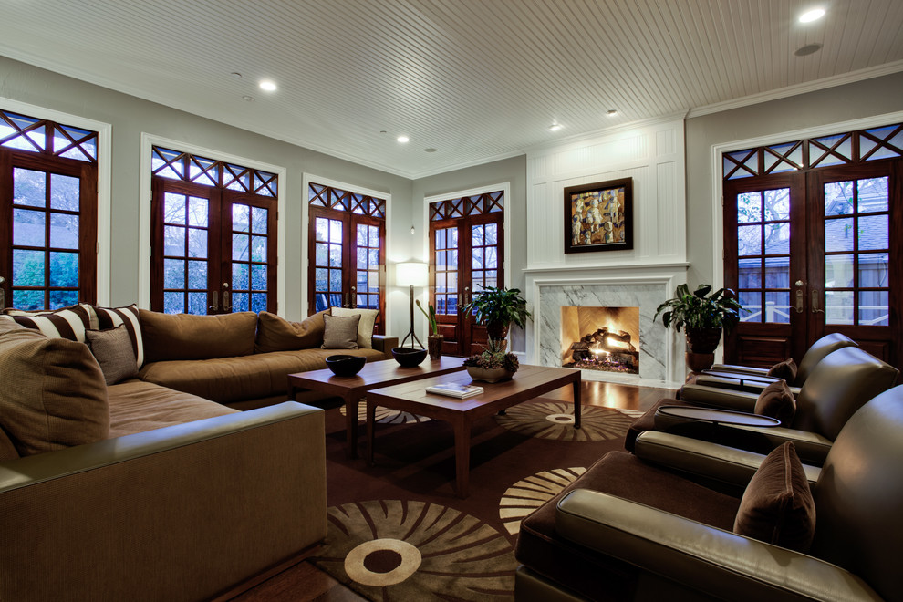 Photo of a large traditional living room in Dallas with grey walls and a standard fireplace.