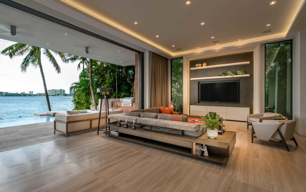 Идея дизайна: огромная открытая гостиная комната в современном стиле с серыми стенами, телевизором на стене, полом из керамогранита и бежевым полом без камина