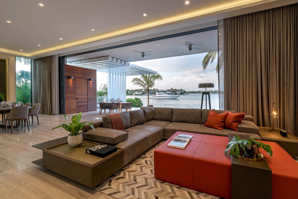 Geräumiges, Offenes Modernes Wohnzimmer ohne Kamin mit grauer Wandfarbe, Porzellan-Bodenfliesen, TV-Wand und beigem Boden in Miami