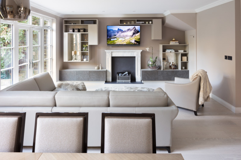 Design ideas for a large romantic open plan living room in London with beige walls, light hardwood flooring, a standard fireplace, a stone fireplace surround and a wall mounted tv.