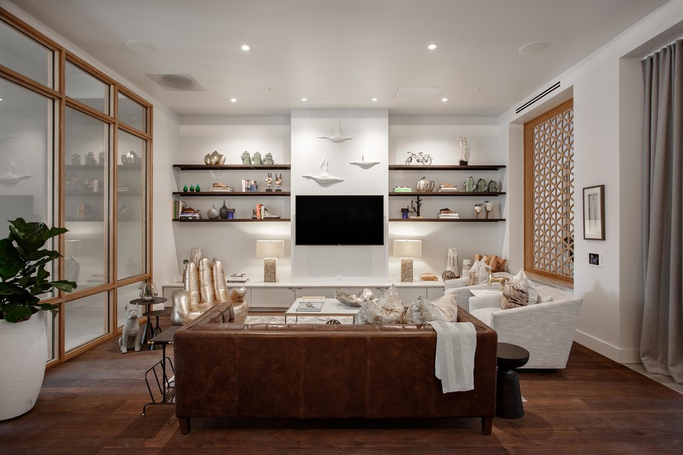 Modelo de salón clásico renovado con paredes blancas, suelo de mármol, televisor colgado en la pared y suelo marrón