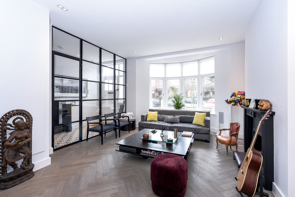 Mittelgroßes, Abgetrenntes Modernes Wohnzimmer mit weißer Wandfarbe, hellem Holzboden, Kaminumrandung aus Metall, braunem Boden und Kamin in London