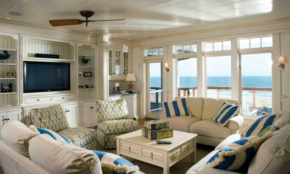 Aménagement d'un salon bord de mer avec une salle de réception et un téléviseur encastré.