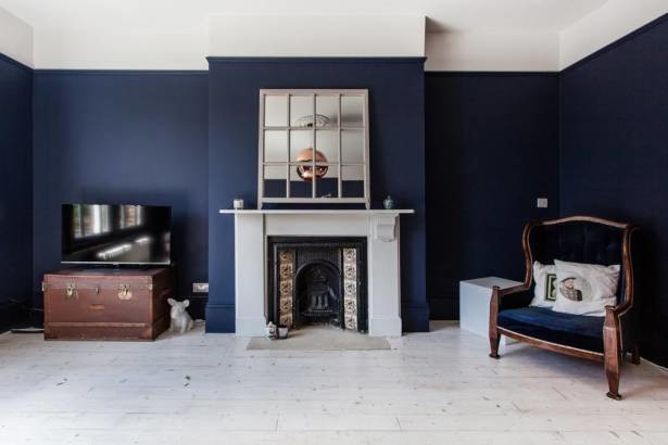 Abgetrenntes Klassisches Wohnzimmer mit blauer Wandfarbe, hellem Holzboden, Kamin und Kaminumrandung aus Holz in London